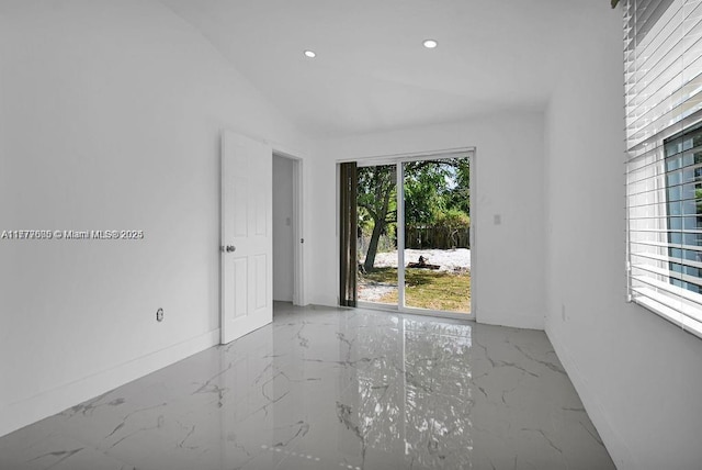 unfurnished room with lofted ceiling, recessed lighting, marble finish floor, and baseboards