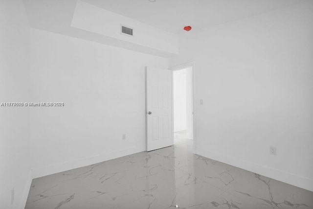 unfurnished room with baseboards, visible vents, and marble finish floor
