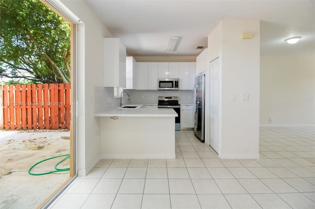 12376 SW 126th Ave Unit 12376, Miami, FL 33186 - kitchen featuring appliances with stainless steel finishes, a sink, light countertops, a peninsula, and white cabinets
