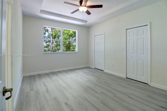 12376 SW 126th Ave Unit 12376, Miami, FL 33186 - unfurnished bedroom featuring two closets, wood finished floors, a raised ceiling, baseboards, and ceiling fan