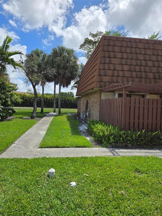 view of community featuring fence and a yard