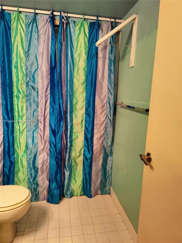 bathroom with tile patterned floors, a shower with curtain, and toilet