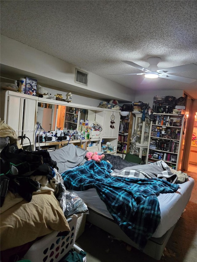 interior space with a textured ceiling, visible vents, and ceiling fan