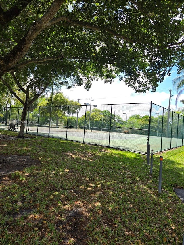view of tennis court featuring fence