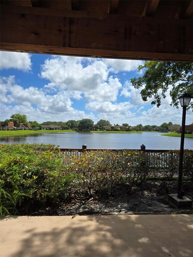 view of patio / terrace with a water view and fence