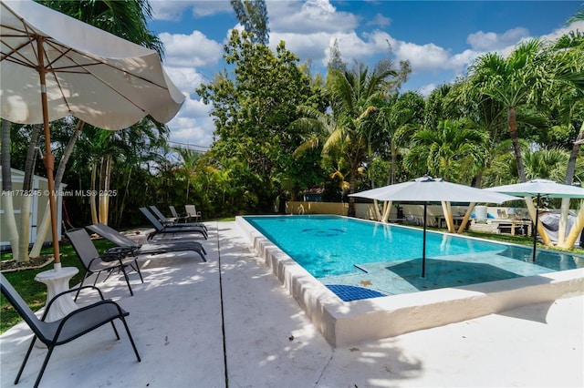community pool featuring a patio and fence