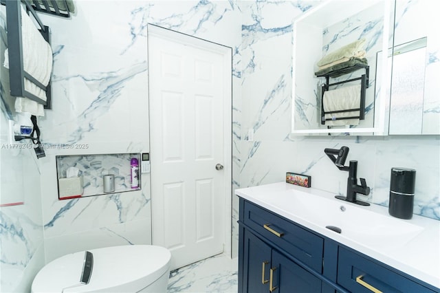 bathroom featuring tile walls, marble finish floor, vanity, and toilet