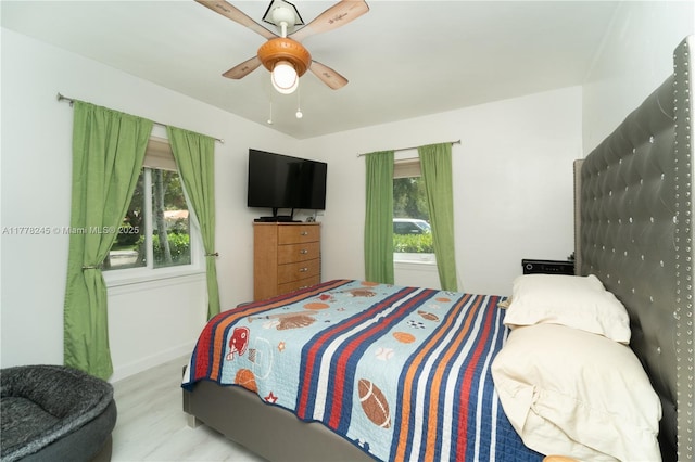 bedroom featuring baseboards, a ceiling fan, and wood finished floors