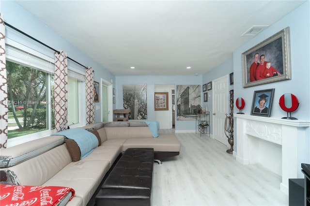 living area with recessed lighting, wood finished floors, visible vents, and baseboards