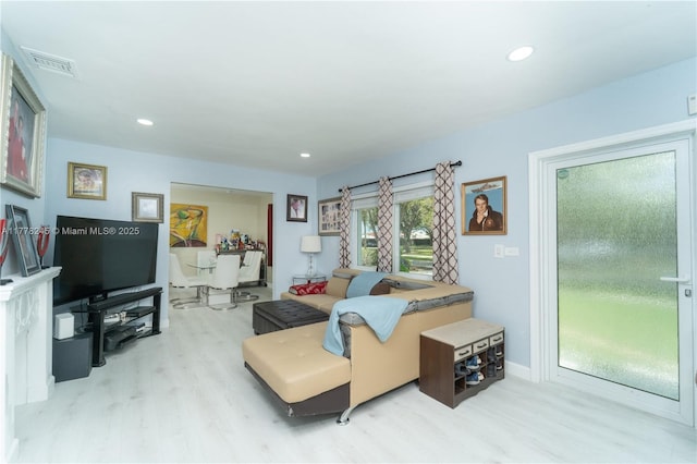 living area with wood finished floors, visible vents, and recessed lighting