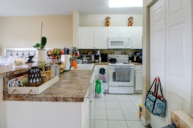 kitchen featuring white cabinets, light tile patterned floors, a sink, and white appliances