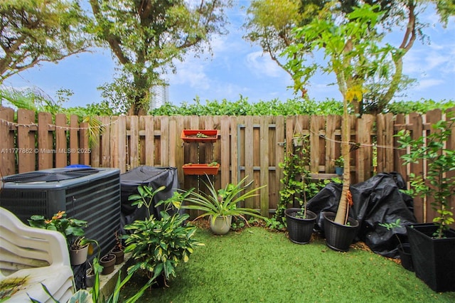 view of yard featuring a fenced backyard and central AC