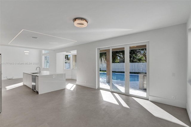852 Heritage Dr, Weston, FL 33326 - unfurnished living room featuring healthy amount of natural light, a sink, baseboards, and concrete flooring