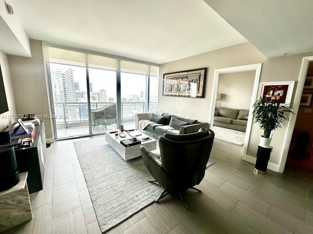 92 SW 3rd St Unit 4104, Miami, FL 33130 - living area with floor to ceiling windows, a city view, and wood finished floors