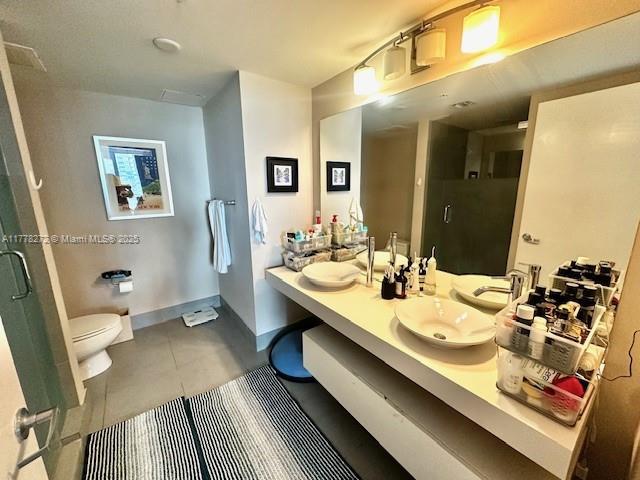 92 SW 3rd St Unit 4104, Miami, FL 33130 - full bathroom featuring toilet, a stall shower, double vanity, and tile patterned floors