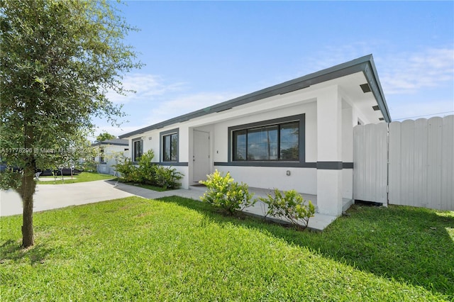 view of front facade with stucco siding and a front yard