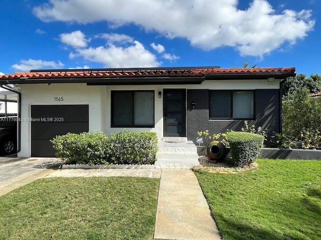 view of front facade with a tile roof, a front yard, and a garage