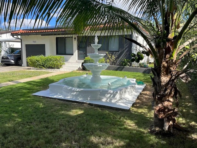 surrounding community with an attached garage and a yard