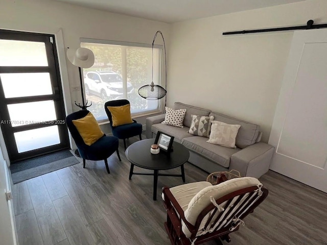 living area with a barn door and wood finished floors