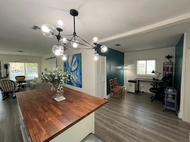 dining room with a notable chandelier, dark wood-type flooring, and visible vents