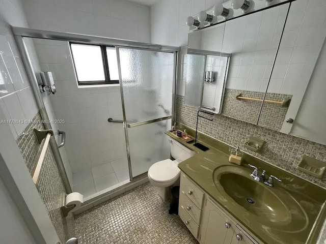 full bath with tile walls, a shower stall, toilet, vanity, and tasteful backsplash