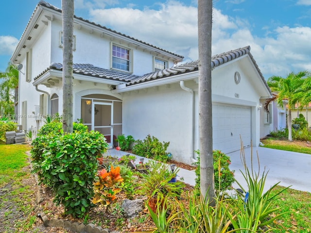 view of front of house with a tile roof, stucco siding, a garage, and concrete driveway