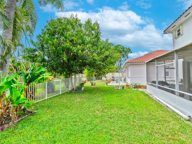 view of yard featuring a fenced backyard and a sunroom