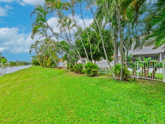 view of yard featuring a water view and fence