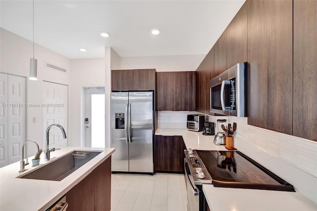 4740 NW 84th Ct Unit 32, Doral, FL 33166 - kitchen with light countertops, a sink, appliances with stainless steel finishes, modern cabinets, and dark brown cabinets