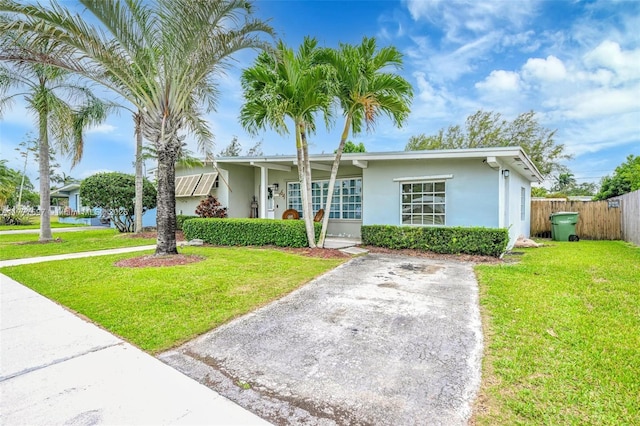 single story home featuring a front yard, fence, and stucco siding