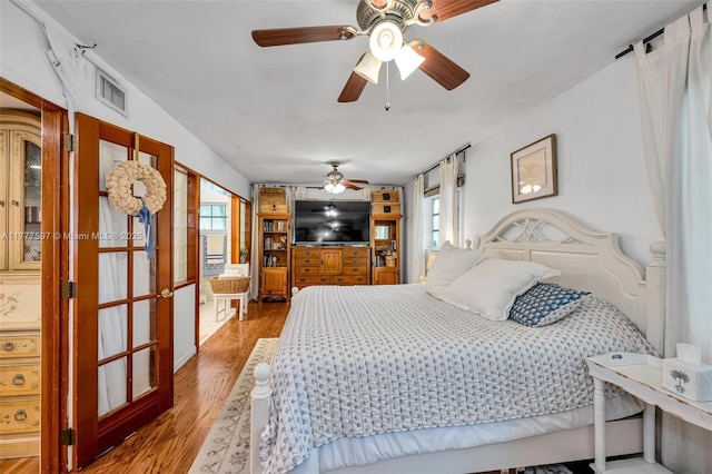 bedroom featuring visible vents, french doors, and wood finished floors
