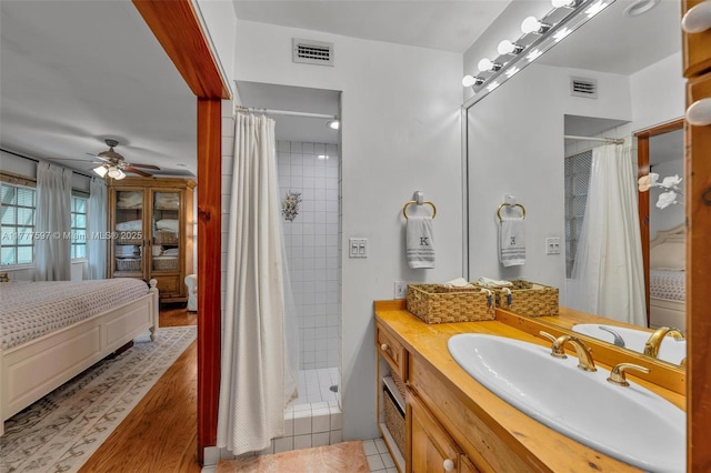 full bath with connected bathroom, a shower stall, vanity, a ceiling fan, and visible vents