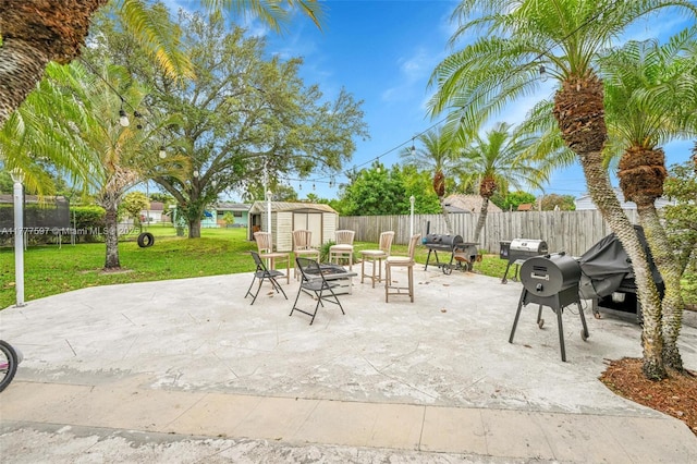 view of patio / terrace with a trampoline, a fenced backyard, an outbuilding, and a storage unit