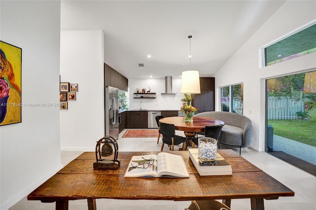 dining area with recessed lighting, baseboards, visible vents, and a towering ceiling