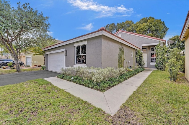 view of front of house with a garage, stucco siding, a front yard, a tiled roof, and driveway
