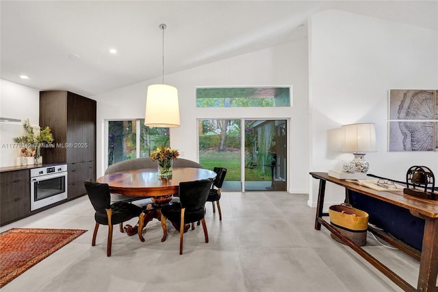 dining area featuring recessed lighting, concrete floors, and high vaulted ceiling