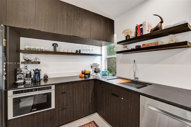 kitchen with open shelves, a sink, dark brown cabinets, and stainless steel appliances