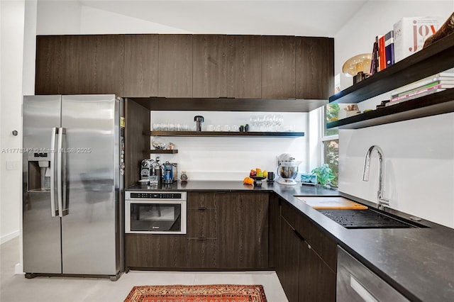 kitchen with open shelves, a sink, appliances with stainless steel finishes, and dark brown cabinetry