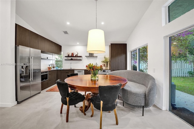 dining area featuring vaulted ceiling, visible vents, plenty of natural light, and finished concrete floors