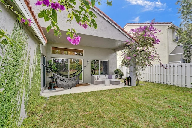 back of house with a lawn, a patio area, fence, outdoor lounge area, and stucco siding