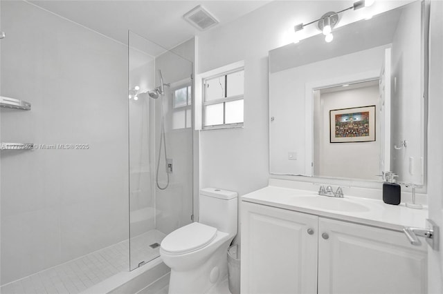 full bathroom featuring visible vents, vanity, toilet, and tiled shower