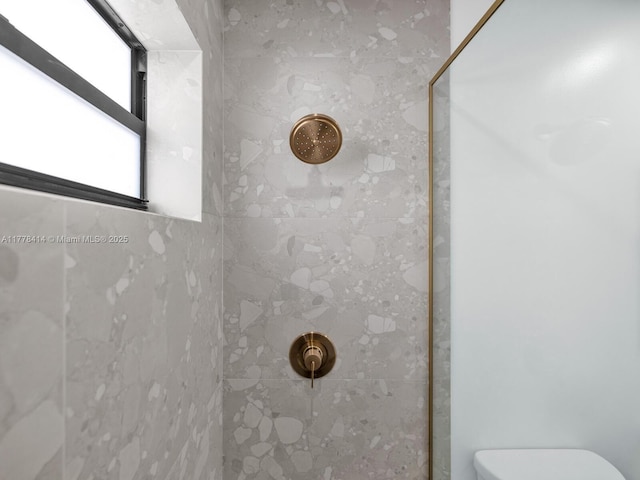 full bath featuring toilet and tiled shower