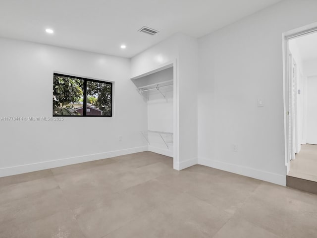 unfurnished bedroom with a walk in closet, visible vents, baseboards, and recessed lighting