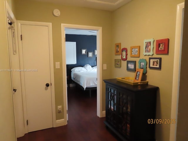 hall with dark wood-style floors and baseboards