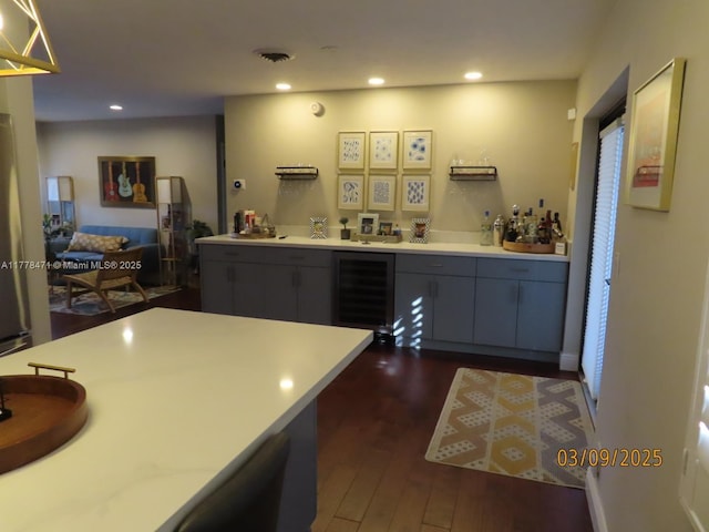 interior space featuring light countertops, recessed lighting, dark wood finished floors, beverage cooler, and gray cabinets