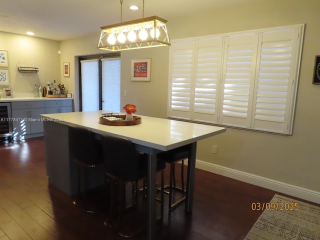 dining area with baseboards, a dry bar, dark wood-style flooring, and recessed lighting