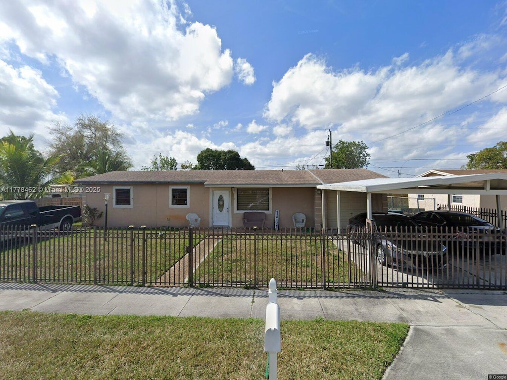 single story home featuring a carport, stucco siding, a front lawn, a fenced front yard, and a garage