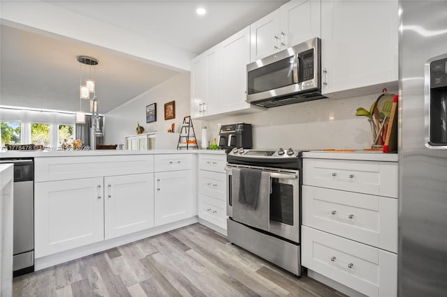 kitchen featuring white cabinetry, light countertops, decorative light fixtures, stainless steel appliances, and light wood finished floors