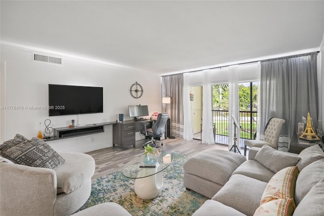 living area with visible vents and wood finished floors