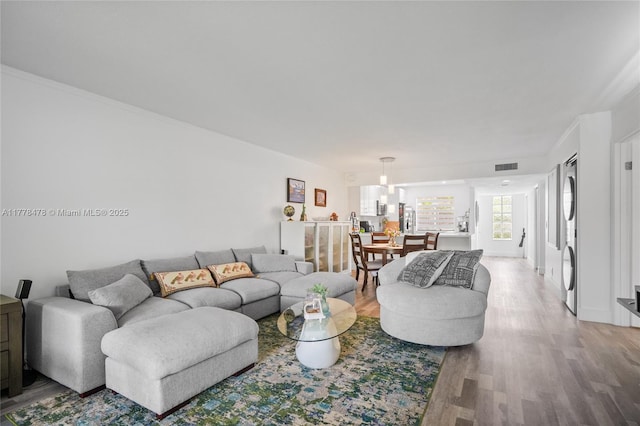 living area featuring visible vents and wood finished floors